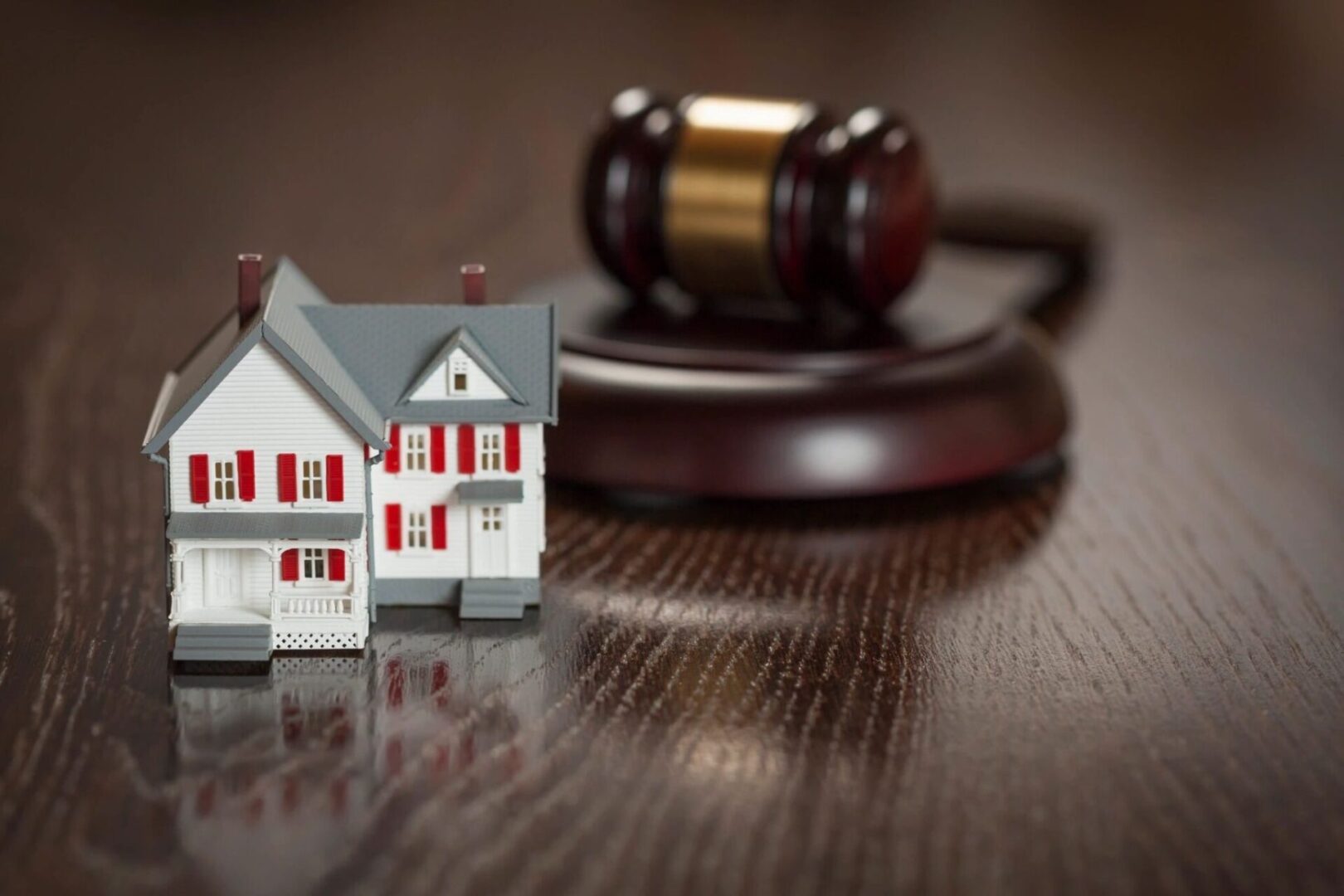 Gavel and Small Model House on Wooden Table.